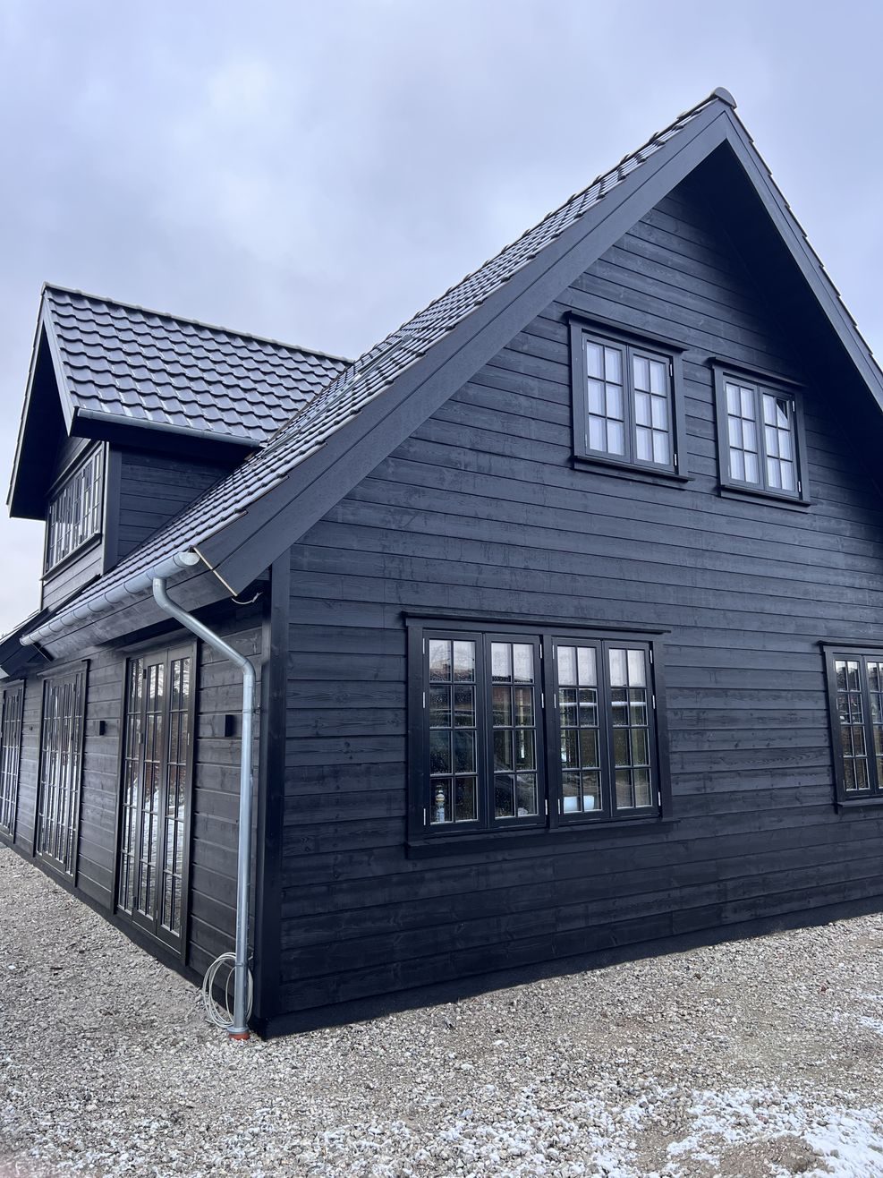 Sort træhus efter renovering på Møn